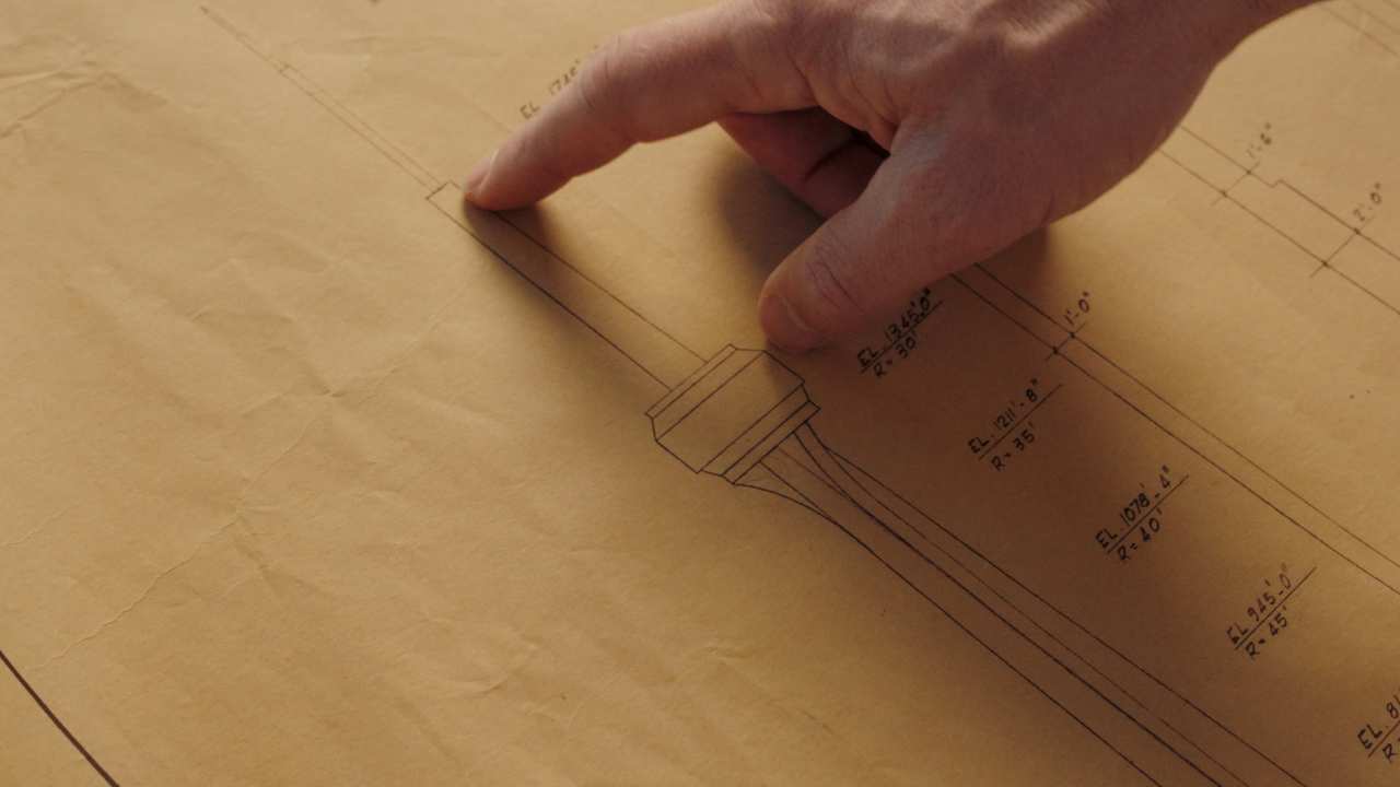 closeup of a persons hand & CN Tower plans